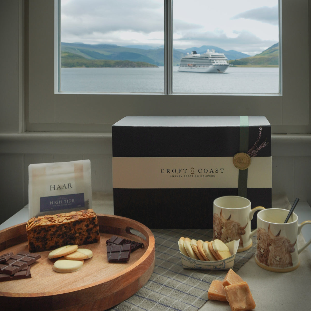 Croft and coast embers collection. infront of a window view of Ullapool loch broom and viking cruise ship